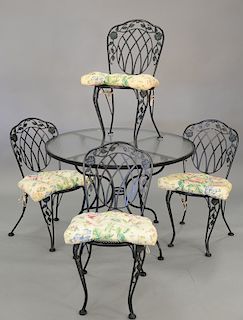 Iron five piece patio set with round glass top table and four chairs. ht. 28 1/2 in., dia. 42 in.