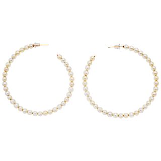 A cultured pearl 14K yellow gold pair of hoop earrings.