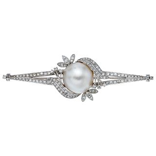 A half pearl and diamond palladium silver brooch.
