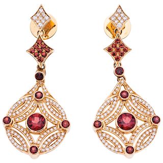 A garnet and diamond 18K yellow gold pair of earrings.