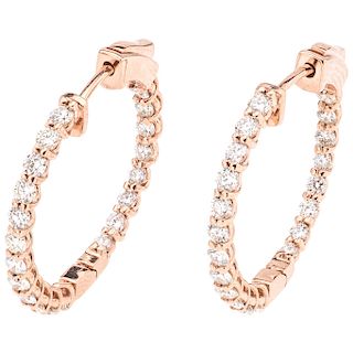 A diamond 14K rose gold pair of hoop earrings.