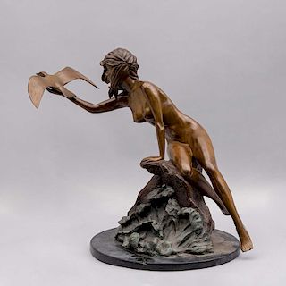 Escultura de mujer con ave. Siglo XX. Fundición en bronce patinado sobre base circular de mármol negro.