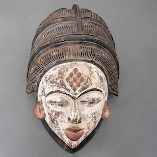 Máscara de Okuyi / Mukuyi. Gabón, Siglo XX. Grupo étnico Punu. Talla en madera, pigmentos y caolín.Con una escala en forma de diamante.
