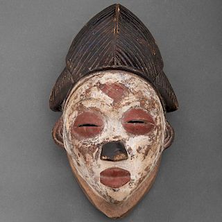 Máscara de Okuyi/Mukuyi. Gabón, Siglo XIX. Grupo étnico Punu. Talla en madera, pigmentos y caolín. Con escala en forma de diamante.