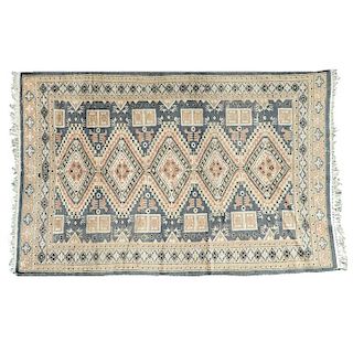 Tapete. Pakistán, siglo XX. Estilo Bokhara.Anudada a mano en fibras de lana y algodón. Decorada con motivos romboidales y geométricos.