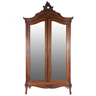 Armario. Francia. SXX. En talla de madera de nogal. 2 puertas abatibles con espejo de luna irregular biselada y soportes semicurvos.