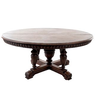 Mesa-pedestal. Francia. Siglo XX. Estilo Enrique II. En talla de madera de nogal. Con cubierta oval, fustes tipo jarrón.