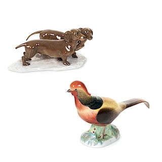 Lote de 2 figuras decorativas. Siglo XX. Elaboradas en porcelana. Consta de: ave y perros salchicha de porcelana.