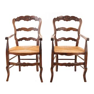 Par de sillones. Francia. Siglo XX. Estilo Luis XV. En talla de madera de nogal. Con respaldos semiabiertos, asientos de palma tejida.