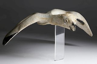 CARVED AND PAINTED INUIT WHALE VERTEBRAE IN THE FORM OF AN ARTIC GYRFALCON IN FLIGHT