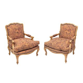 Par de sillones. Siglo XX. Estilo Luis XV. Estructura de madera. Respaldos cerrados, con asientos acojinados en tapicería de textil.