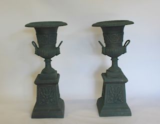 Pair Of Cast Iron Urns On Stands.