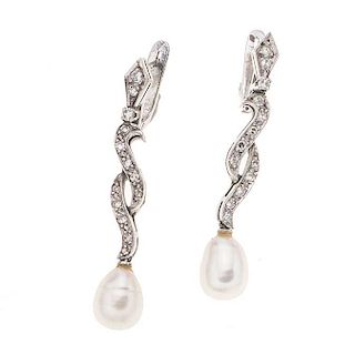 Par de aretes con perlas y diamantes en oro blanco de 10k. 2 perlas cultivadas de gota. 26 acentos de diamantes. Peso: 5.5 g.