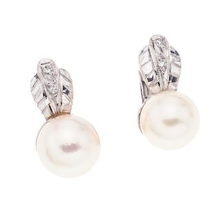 Par de aretes con perlas y diamantes en plata paladio. 2 perlas cultivadas color crema de 8 mm. 4 acentos de diamantes. Peso:...
