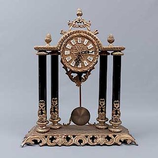 Reloj de mesa. Origen europeo. Siglo XX. Estilo imperio. Elaborado en bronce. Mecanismo de cuarzo y péndulo.