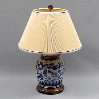 Lámpara de mesa. Origen oriental. Siglo XX. Elaborado en cerámica color blanco y azul. Con base de madera y pantalla de tela.
