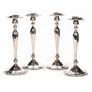 Four sterling candlesticks.