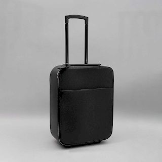 Maleta de viaje. Siglo XX. De la marca Louis Vuitton. Elaborada en piel color negro, con ruedas y agarredera retractil. 48 x 35 x 18 cm