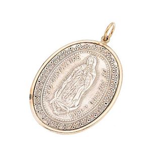 Medalla en plata .925 y oro amarillo de 12k. Imagen de Virgen de Guadalupe. Bisel oro amarillo de 12k. Peso: 14.8 g.