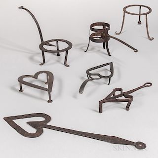 Six Wrought Iron Trivets and a Heart-shaped Tool
