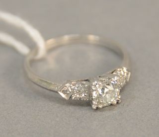 Platinum ring set with center diamond approx. .50 cts flanked by small diamonds.