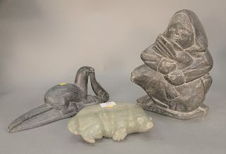 Three Eskimo soapstone figures; seal with fish signed illegibly on bottom, polar bear, and a large Eskimo holding a seal, tallest ht...