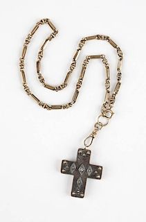 A gold cruciform pendant on an antique fob chain