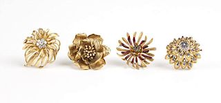 A group of four gold floral brooches