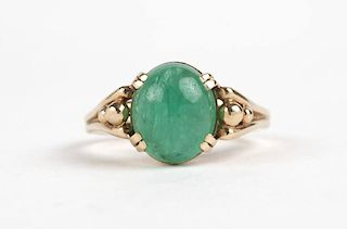 An emerald cabochon and gold ring