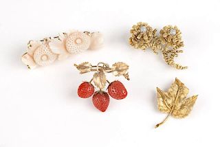 A collection of four stone and gold brooches