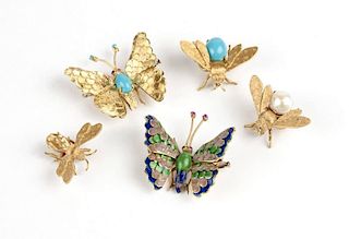A collection of gold winged brooches