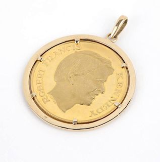 A gold Kennedy coin in gold bezel pendant