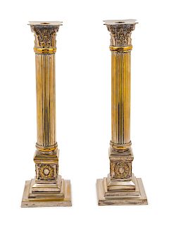 A Pair of Silvered Metal Candlesticks<br>in the f