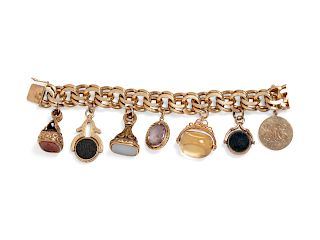 A 14 Karat Yellow Gold Bracelet With Seven Attached Fobs and Charms,