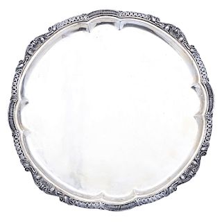 TRAY. MEXICO, 20TH CENTURY. Sterling 0.925 Silver. Brand: SANBORNS. Circular with undulating rims, embossed and chased with vegetal decoration and cla