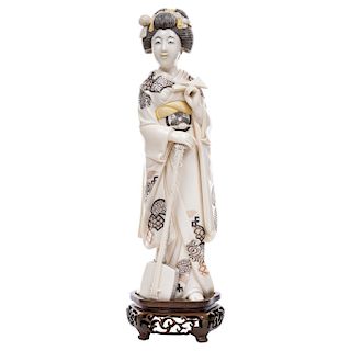 GEISHA PLAYING THE SHAMISEN.  JAPAN, BEGINNING OF THE 20TH CENTURY. Carved ivory model with ink detail, on a wooden stand.