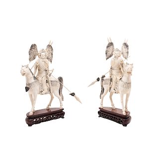 EMPEROR AND EMPRESS ON HORSEBACK IN BATTLE REGALIA. CHINA. 20TH CENTURY. A pair of carved ivory models with ink details, on a wooden stand.