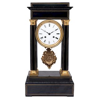 PORTICO MANTEL CLOCK. FRANCE, 19TH CENTURY. Ebonised wood with bronze and brass details. Winding mechanism.