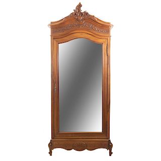 Armario. Francia. SXX. Estilo Luis XV. En talla de madera de nogal. Puerta con espejo de luna irregular biselada. 238 x 104 x 53 cm.