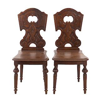 Par de sillas. Francia. Siglo XX. En talla de madera de roble. Con respaldos irregulares semiabiertos y asiento de madera.