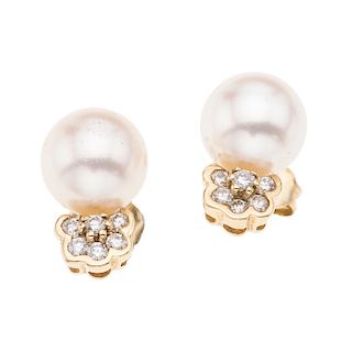 Par de broqueles con perlas y diamantes en oro amarillo 14k. 2 perlas cultivadas color blanco de 8 mm. 12 acentos de diamantes.<...