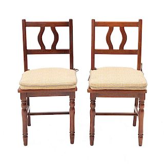 Par de sillas. Siglo XX. Elaboradas en madera tallada. Respaldos semiabierto, asientos acojinados, chambrana H y soportes tipo carrete.