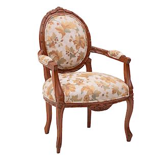 Sillón. Siglo XX. Estructura de madera. Respaldo y asiento en tapicería floral color beige y soportes tipo cabriolé.