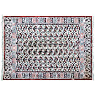 Tapete. Pakistán, siglo XX. Estilo Bokhara. Elaborado en fibras de lana y algodón. Decorado con motivos geométricos sobre fondo marfil.