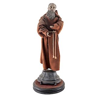 SAINT FRANCIS OF PAULA. MEXICO, 19TH CENTURY. Carved wood figure decorated with glass eyes and clothing. Metal base with glass cover.