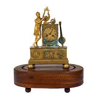 MANTEL CLOCK. FRANCE, CIRCA 1900. Gilt bronze clock with the figure of Apolo. The base wooden and a glass cover. 