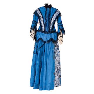 DRESS. CIRCA 1900. Blue fabric with floral decoration and details in black velvet, lace and chiffon.
