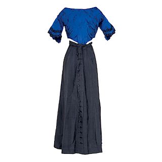 BLOUSE AND SKIRT SET. CIRCA 1900. Blue blouse with rigid bodice (corset-like structure) and black velvet details. Black plaid skirt.