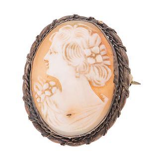 PRENDEDOR CON CAMAFEO Camafeo tallado sobre concha con imagen de dama. Bisel en metal base. Tamaño: 2.8 x 3.8 cm Peso: 6.2 g