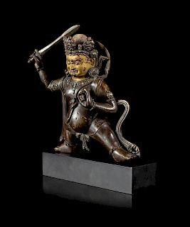 A Sino-Tibetan Parcel-Gilt Bronze Figure of Jambhala
Figure height 8 1/2 in., 22 cm.